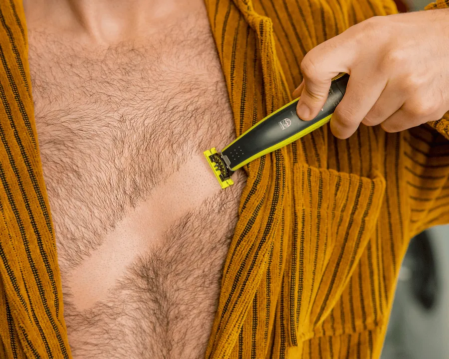 Një burrë që shkurton qimet e kraharorit me Philips OneBlade