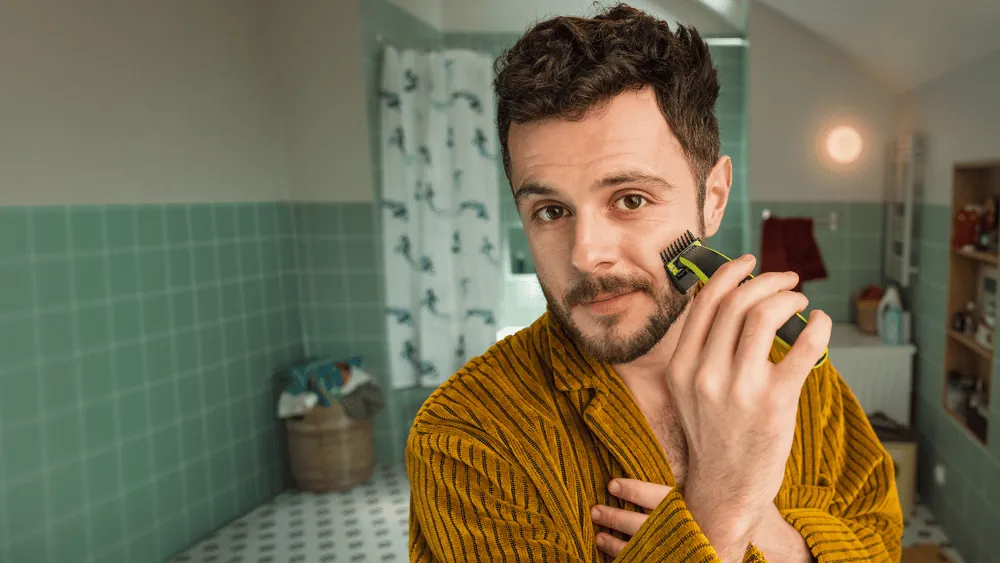 Një burrë që shkurton qimet e fytyrës me Philips OneBlade